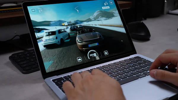 Person playing a racing game on a laptop