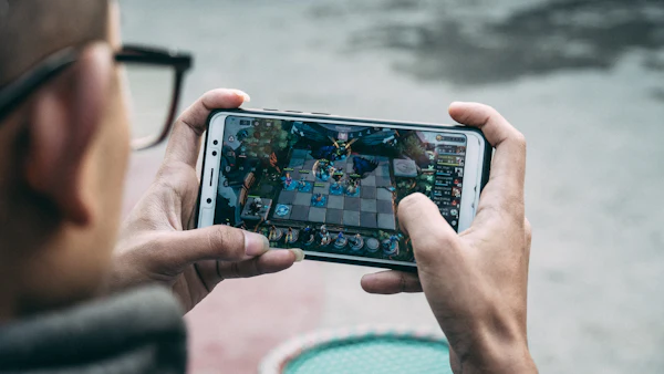 Man playing a game on his Android phone held in both hands