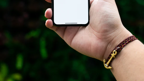 Hand holding an Android smartphone outdoors, ready to install an APK