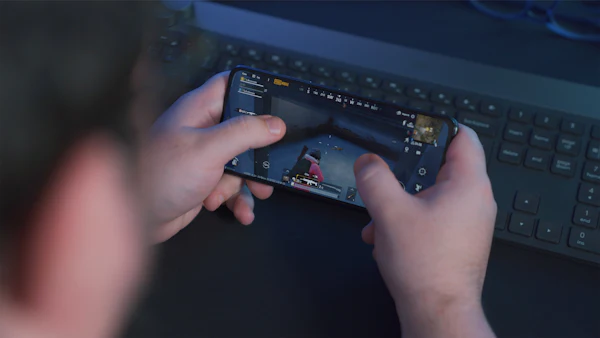 Person holding a black Samsung Android phone and playing a game